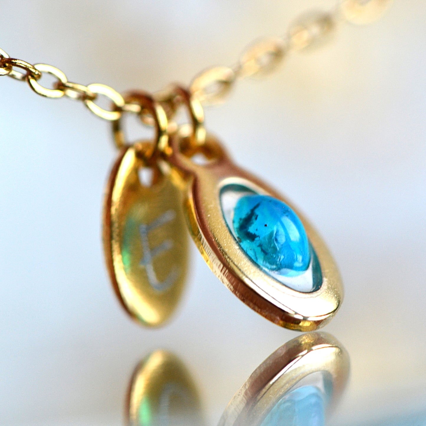 Necklace with opal and initial in gold setting